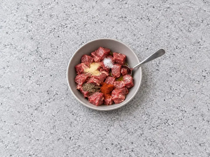 Step 1: Cut the steak into 1-inch cubes. Toss the steak with the oil, salt, garlic powde